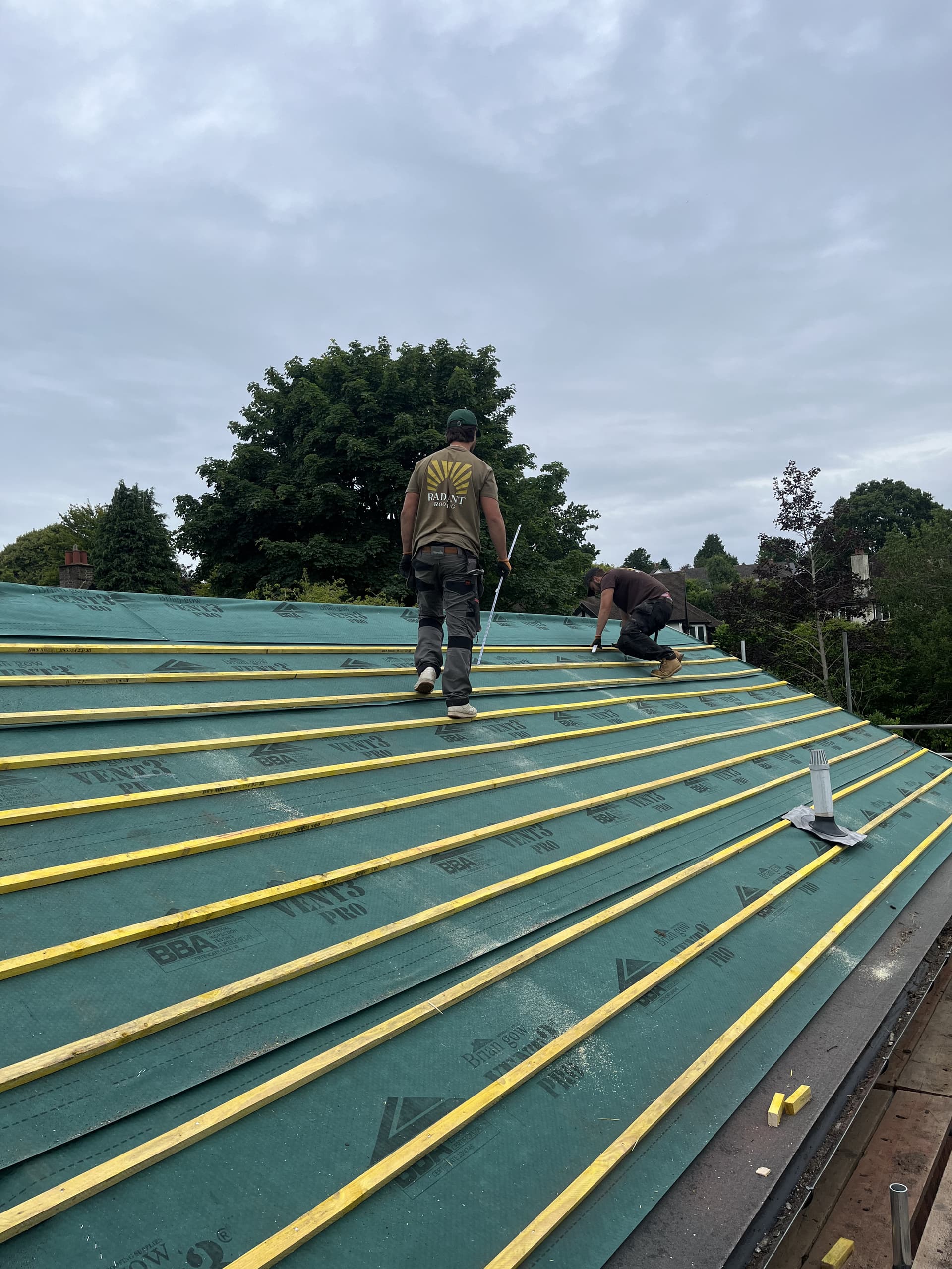 Workers installing battens and membrane